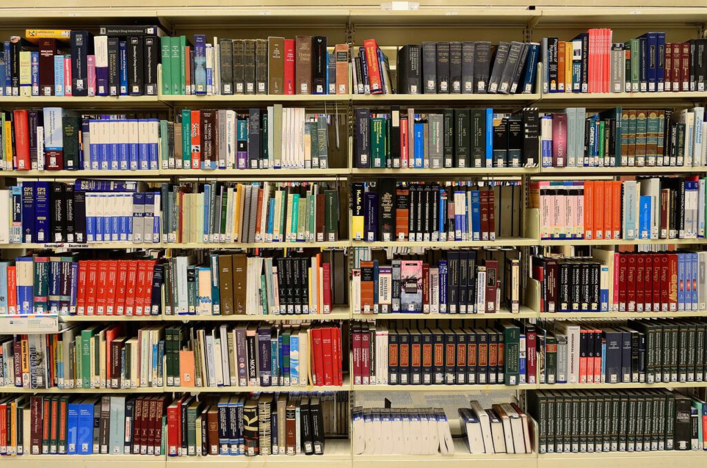 Das Bild zeigt ein großes, mit Fachbüchern gefüllltes Bücherregal in einer Bibliothek.