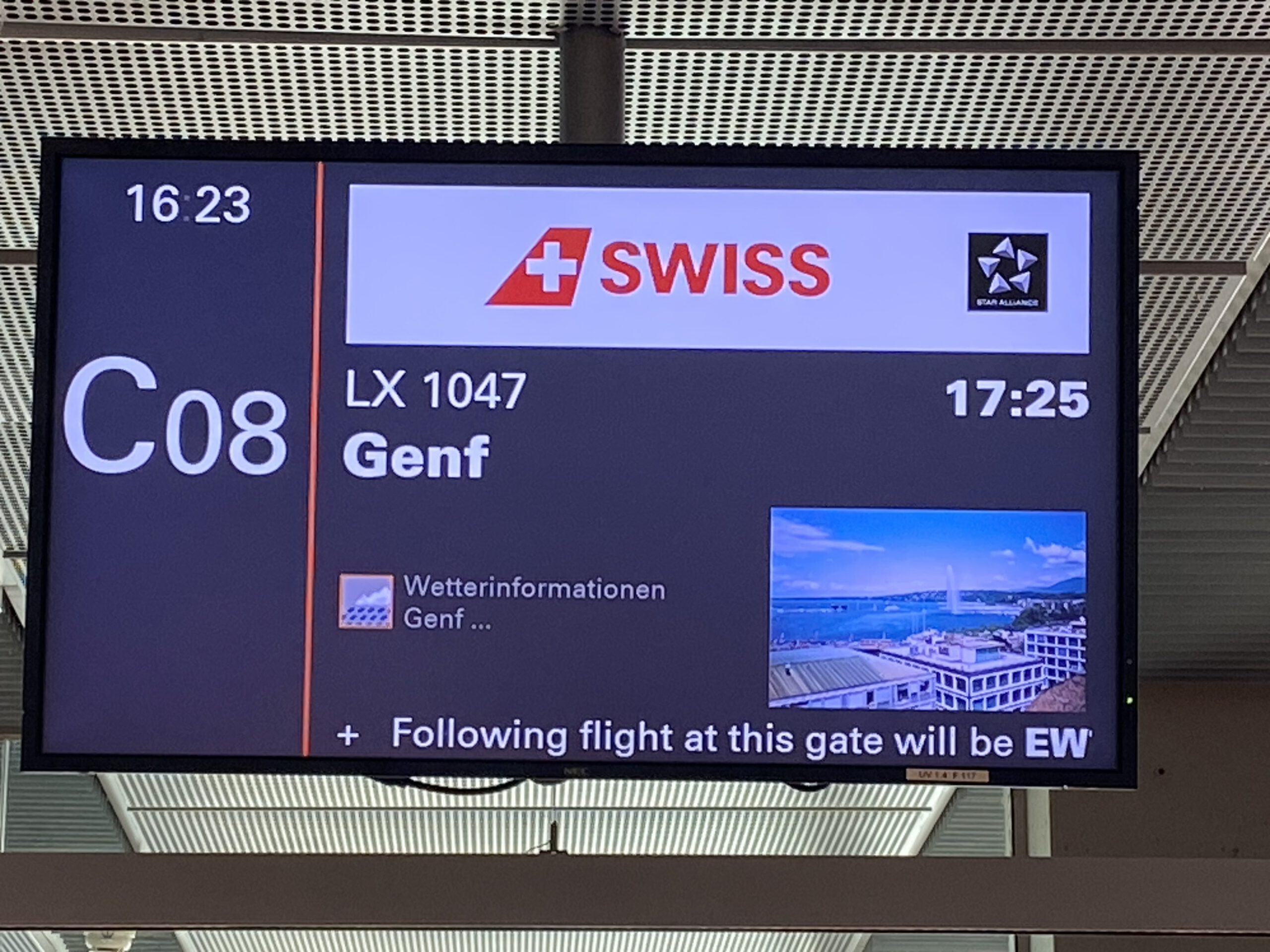 Eine elektronische Anzeigetafel am Hamburger Flughafen zeigt meinen Flug nach Genf an.