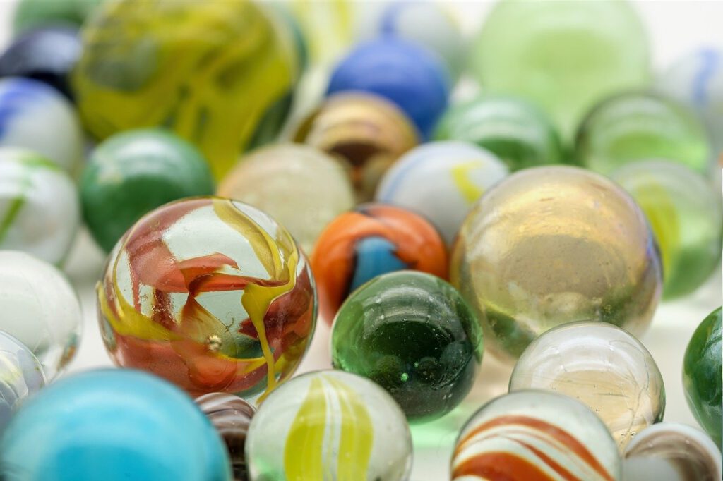 Das Bild zeigt viele Glasmurmeln in unterschiedlichen Farben und Größen
